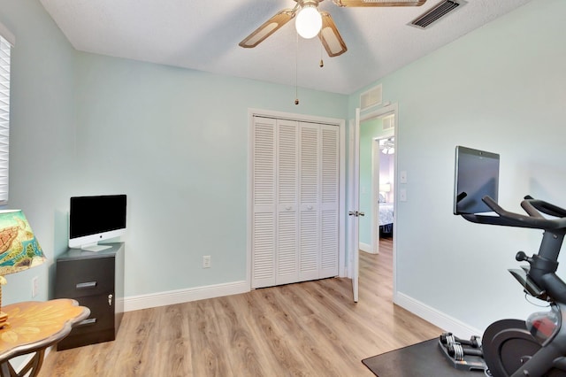 387 Yvonne Dr, West Palm Beach, FL 33406 - exercise room with a ceiling fan, light wood-style floors, and baseboards