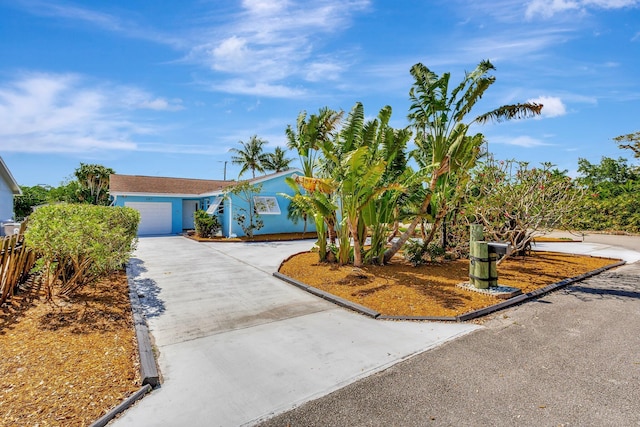 387 Yvonne Dr, West Palm Beach, FL 33406 - view of front of home with concrete driveway, an attached garage, fence, and stucco siding