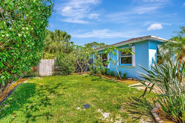 387 Yvonne Dr, West Palm Beach, FL 33406 - rear view of house with a sunroom, stucco siding, a patio area, and a fire pit