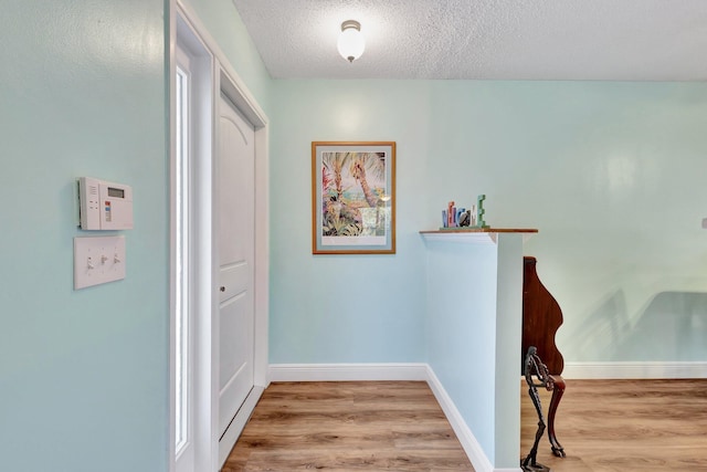 387 Yvonne Dr, West Palm Beach, FL 33406 - hallway with wood finished floors, baseboards, and a textured ceiling