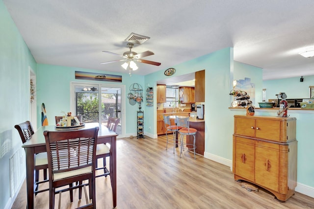 387 Yvonne Dr, West Palm Beach, FL 33406 - dining area with a ceiling fan, light wood finished floors, and baseboards