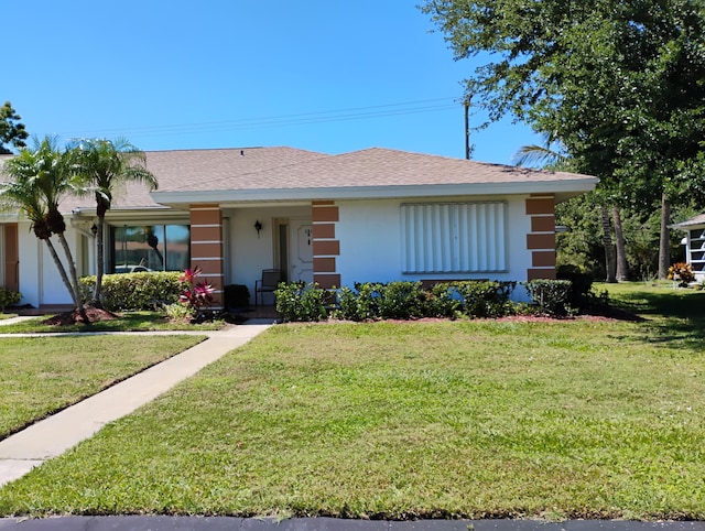131 Lakes End Dr Unit D, Fort Pierce, FL 34982 - ranch-style home with stucco siding, a front yard, and roof with shingles