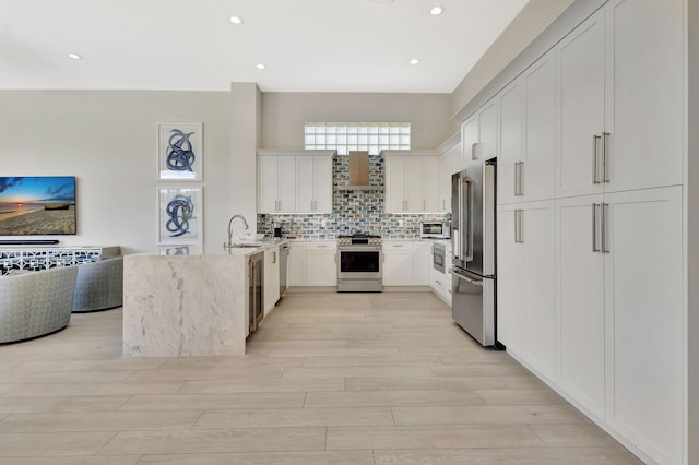 112 Dalena Way, Palm Beach Gardens, FL 33418 - kitchen featuring backsplash, a sink, a peninsula, stainless steel appliances, and light wood-style flooring