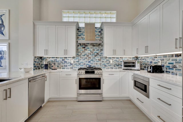 112 Dalena Way, Palm Beach Gardens, FL 33418 - kitchen with stainless steel appliances, decorative backsplash, white cabinetry, and light wood-type flooring