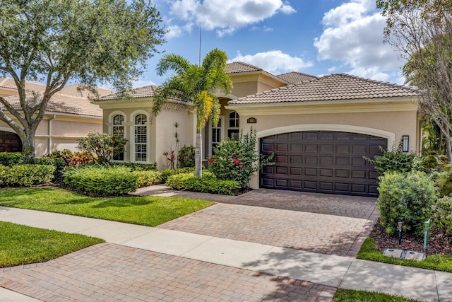 112 Dalena Way, Palm Beach Gardens, FL 33418 - mediterranean / spanish house featuring decorative driveway, a garage, stucco siding, and a tiled roof