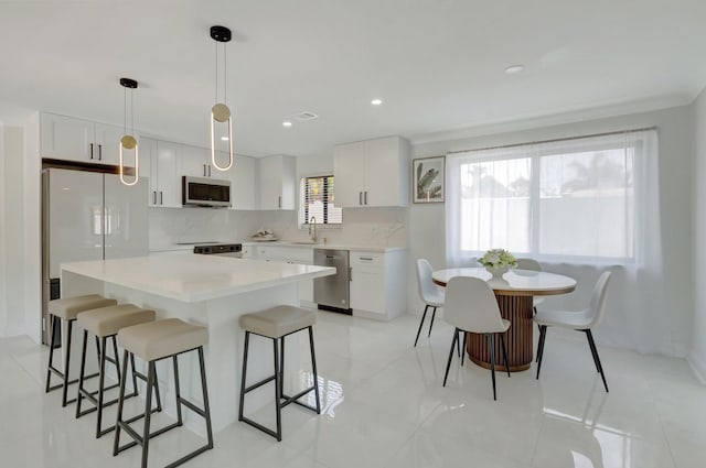 918 Turner Rd, Delray Beach, FL 33483 - kitchen featuring a kitchen breakfast bar, a kitchen island, a sink, stainless steel appliances, and white cabinetry