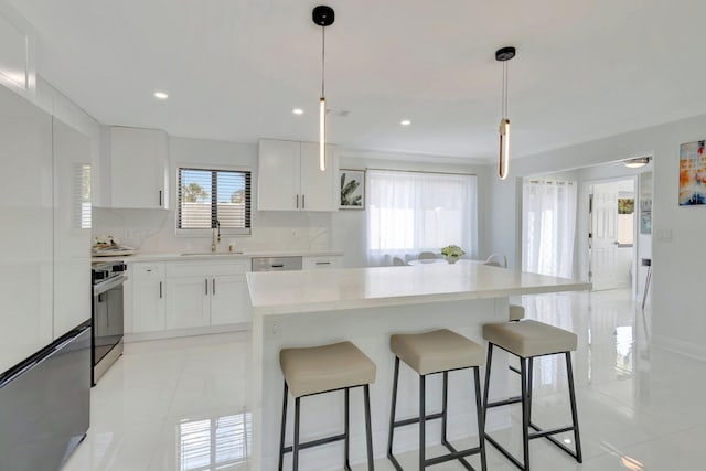 918 Turner Rd, Delray Beach, FL 33483 - kitchen with a kitchen bar, stove, refrigerator, a sink, and light countertops