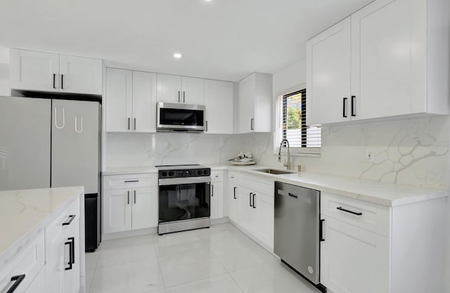 918 Turner Rd, Delray Beach, FL 33483 - kitchen featuring light stone counters, a sink, white cabinetry, and stainless steel appliances
