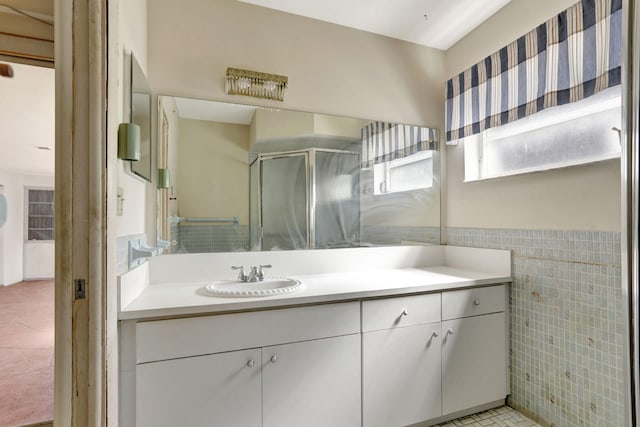 full bathroom featuring wainscoting, vanity, tile patterned floors, tile walls, and a shower stall