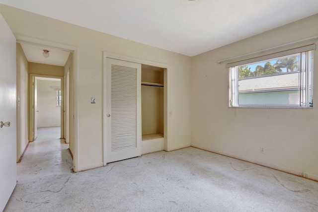 unfurnished bedroom featuring carpet floors, baseboards, and a closet