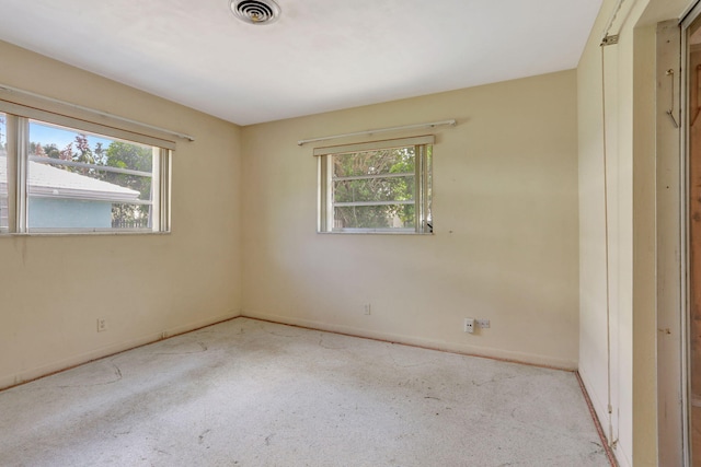 carpeted empty room with baseboards, visible vents, and a healthy amount of sunlight