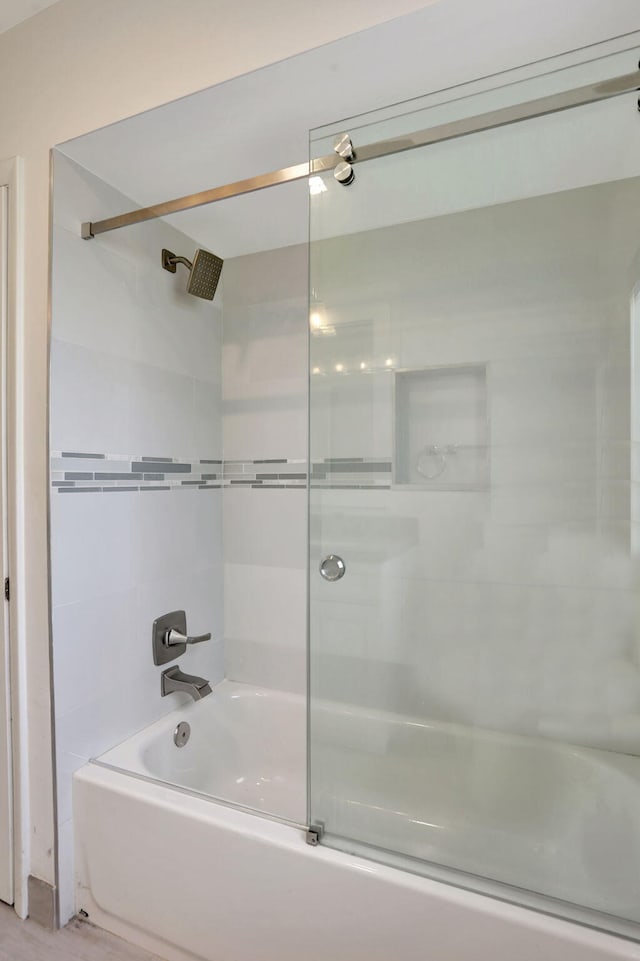 full bath featuring combined bath / shower with glass door