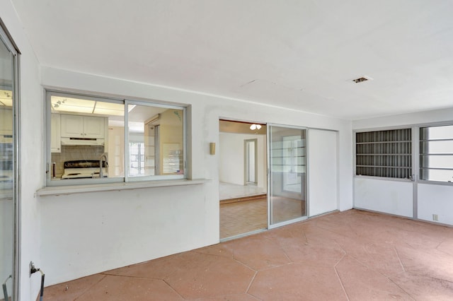 interior space featuring a sink, light tile patterned flooring, and visible vents