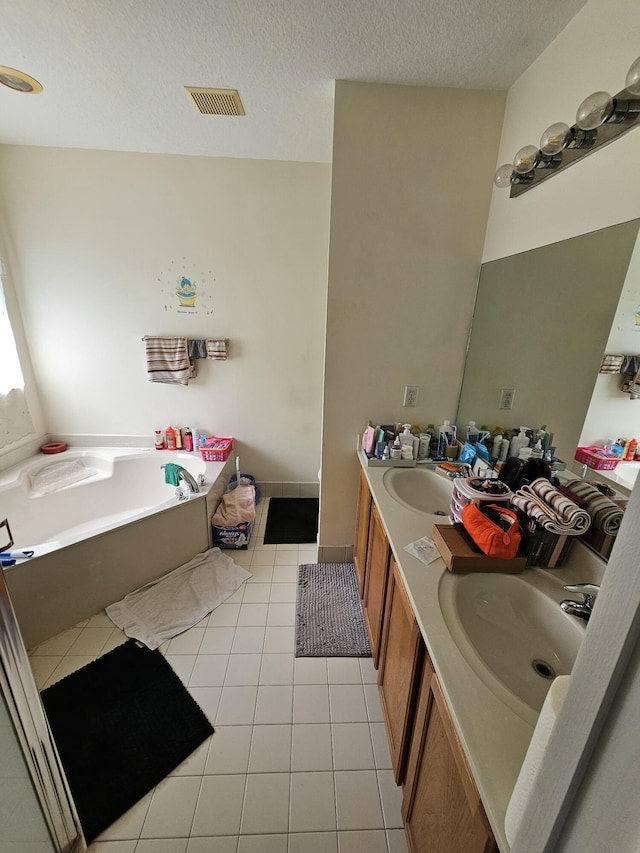 2128 Oakmont Dr Unit 2128, Riviera Beach, FL 33404 - bathroom featuring tile patterned floors, a garden tub, double vanity, and a textured ceiling