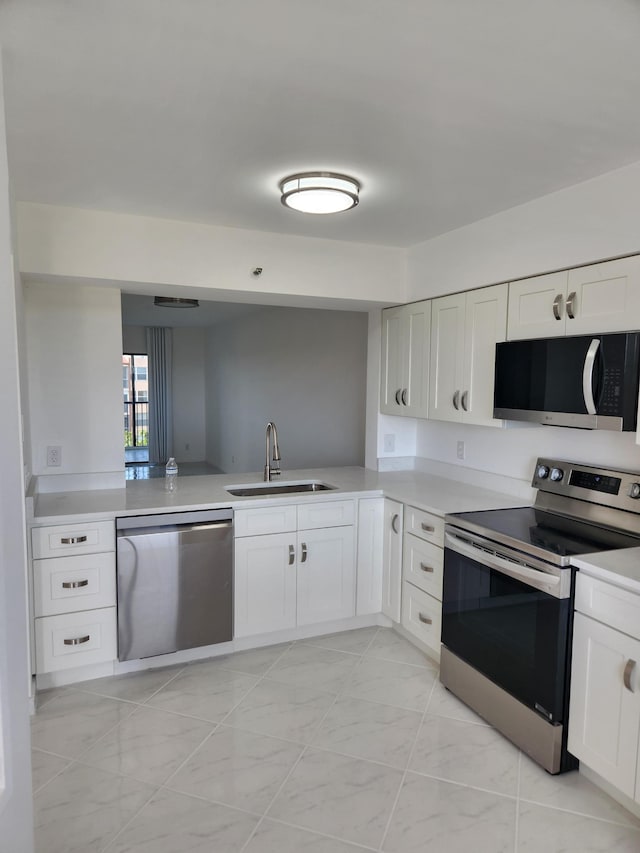 14475 N Strathmore Ln Unit 707, Delray Beach, FL 33446 - kitchen featuring appliances with stainless steel finishes, a sink, light countertops, and white cabinets