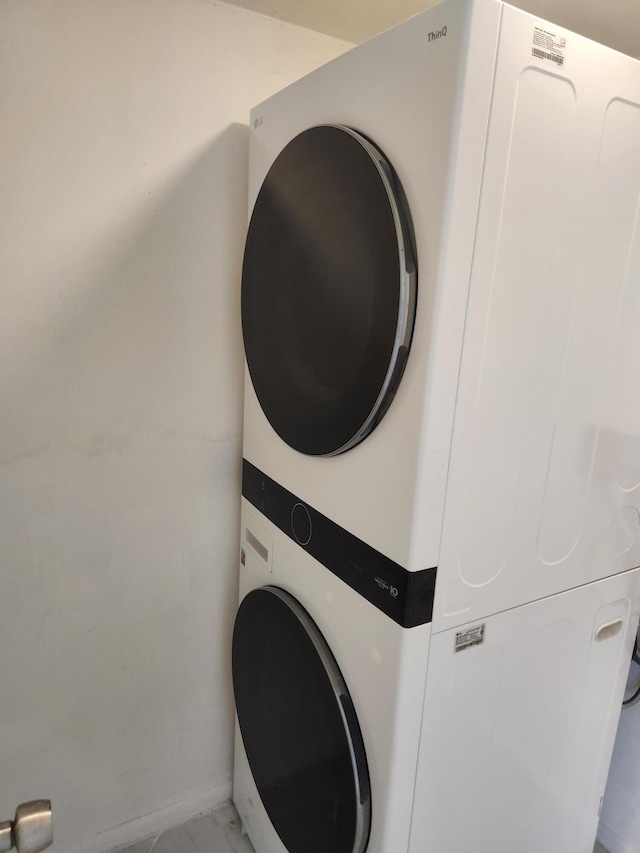 14475 N Strathmore Ln Unit 707, Delray Beach, FL 33446 - washroom with stacked washer and clothes dryer and light marble finish floors