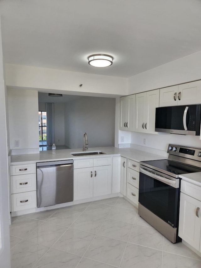 14475 N Strathmore Ln Unit 707, Delray Beach, FL 33446 - kitchen featuring appliances with stainless steel finishes, a sink, light countertops, and white cabinets