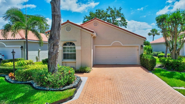 17352 Antigua Point Way, Boca Raton, FL 33487 - mediterranean / spanish-style home with an attached garage, decorative driveway, and stucco siding