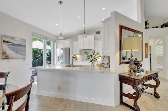 17352 Antigua Point Way, Boca Raton, FL 33487 - kitchen with a peninsula, stainless steel refrigerator with ice dispenser, white cabinets, a sink, and vaulted ceiling
