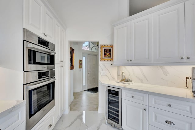 17352 Antigua Point Way, Boca Raton, FL 33487 - kitchen with wine cooler, decorative backsplash, white cabinetry, and marble finish floor