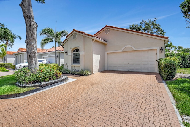 17352 Antigua Point Way, Boca Raton, FL 33487 - mediterranean / spanish home with decorative driveway, a garage, a tile roof, and stucco siding