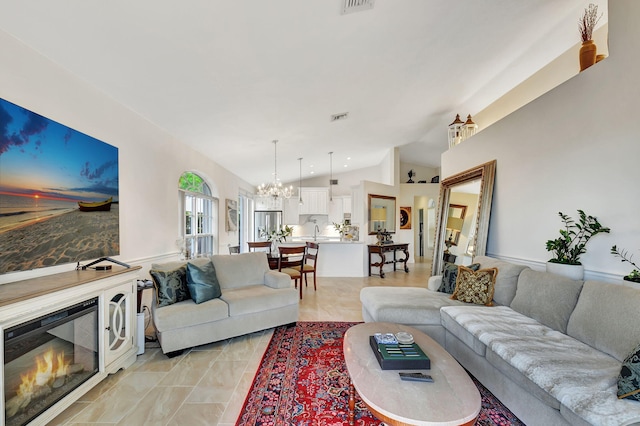 17352 Antigua Point Way, Boca Raton, FL 33487 - living room featuring a chandelier, vaulted ceiling, a glass covered fireplace, and visible vents