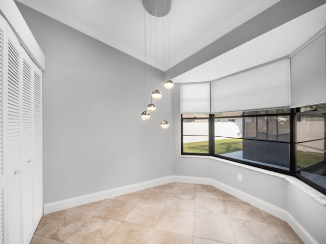 unfurnished dining area with baseboards and tile patterned flooring