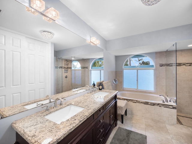 full bathroom featuring a tile shower, a garden tub, and a sink