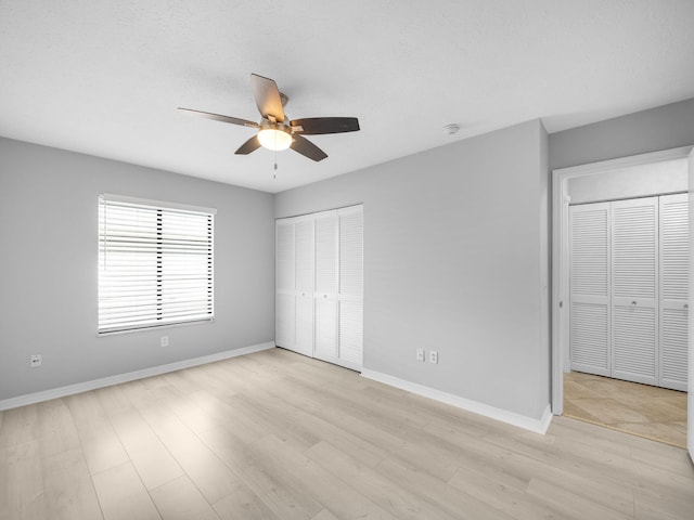 unfurnished bedroom with a ceiling fan, light wood finished floors, and baseboards