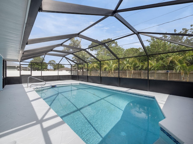 view of swimming pool featuring fence, glass enclosure, a fenced in pool, and a patio area