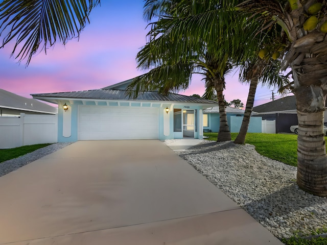 ranch-style house with fence, stucco siding, and driveway