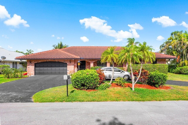 3163 NE 8th Ave, Boca Raton, FL 33431 - view of front of home featuring a tiled roof, a garage, driveway, a front yard, and brick siding