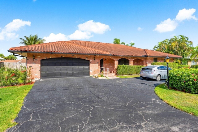 3163 NE 8th Ave, Boca Raton, FL 33431 - view of front of property featuring a tile roof, a garage, driveway, and brick siding