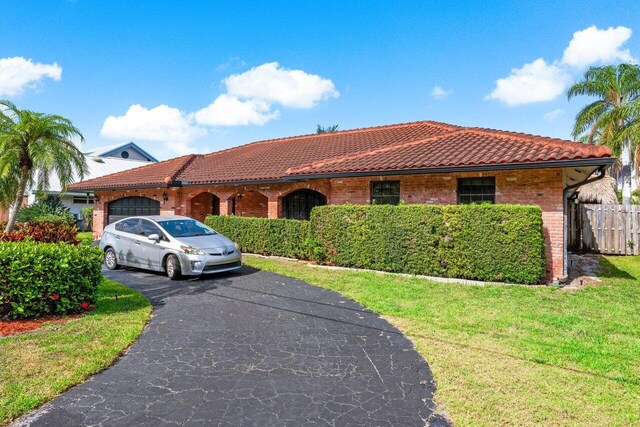3163 NE 8th Ave, Boca Raton, FL 33431 - view of front of property with a tiled roof, a garage, driveway, and brick siding
