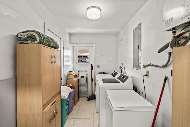 washroom featuring electric panel, light tile patterned floors, washing machine and clothes dryer, and laundry area
