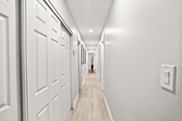 hallway featuring recessed lighting, light wood-style flooring, and baseboards