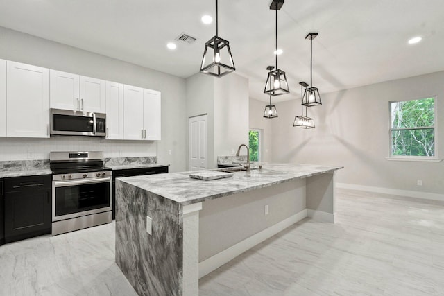 899 Gladiola Ave, Sebastian, FL 32958 - kitchen featuring light stone countertops, stainless steel appliances, white cabinetry, and a wealth of natural light
