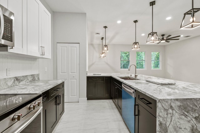 899 Gladiola Ave, Sebastian, FL 32958 - kitchen featuring light stone countertops, appliances with stainless steel finishes, a sink, marble finish floor, and white cabinetry