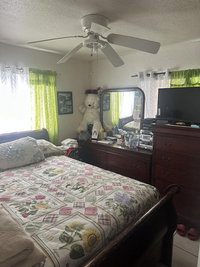 bedroom with a textured ceiling and ceiling fan