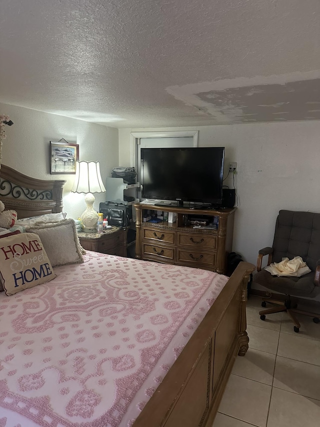 bedroom featuring a textured ceiling and light tile patterned floors
