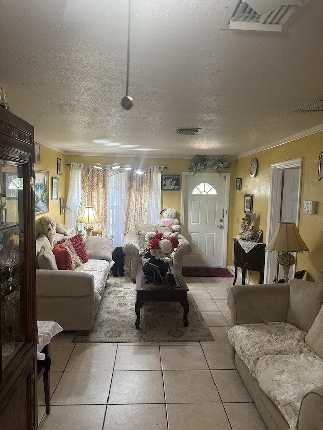 living area with light tile patterned floors, a textured ceiling, visible vents, and ornamental molding