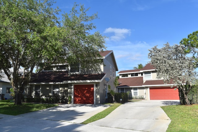 view of front of home with stucco siding, concrete driveway, a front lawn, and a garage