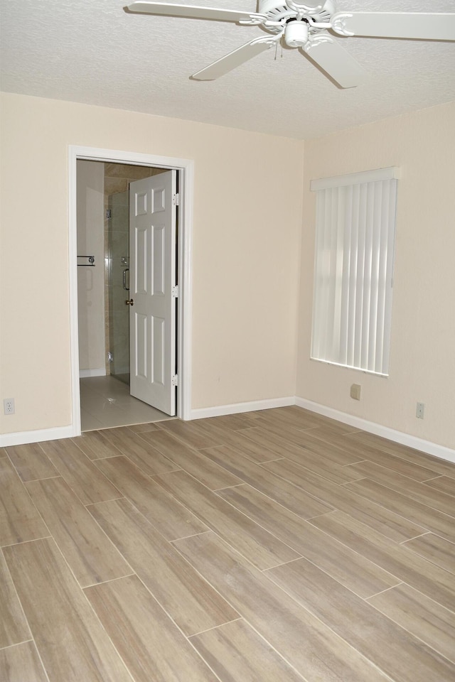 unfurnished room with baseboards, a ceiling fan, and light wood finished floors