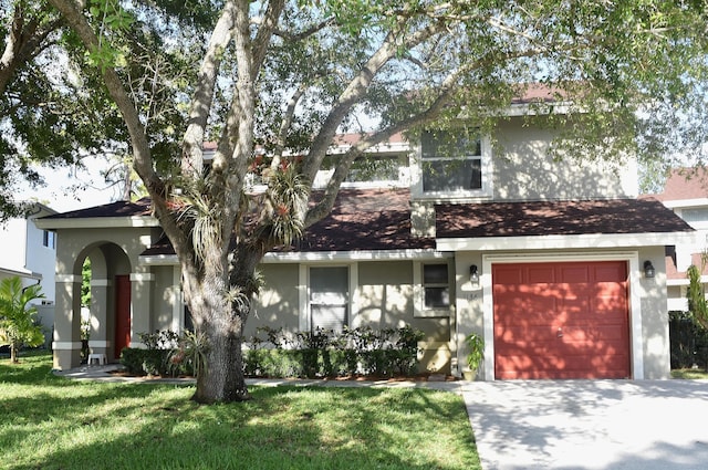 view of front of house featuring stucco siding, a front yard, and an attached garage