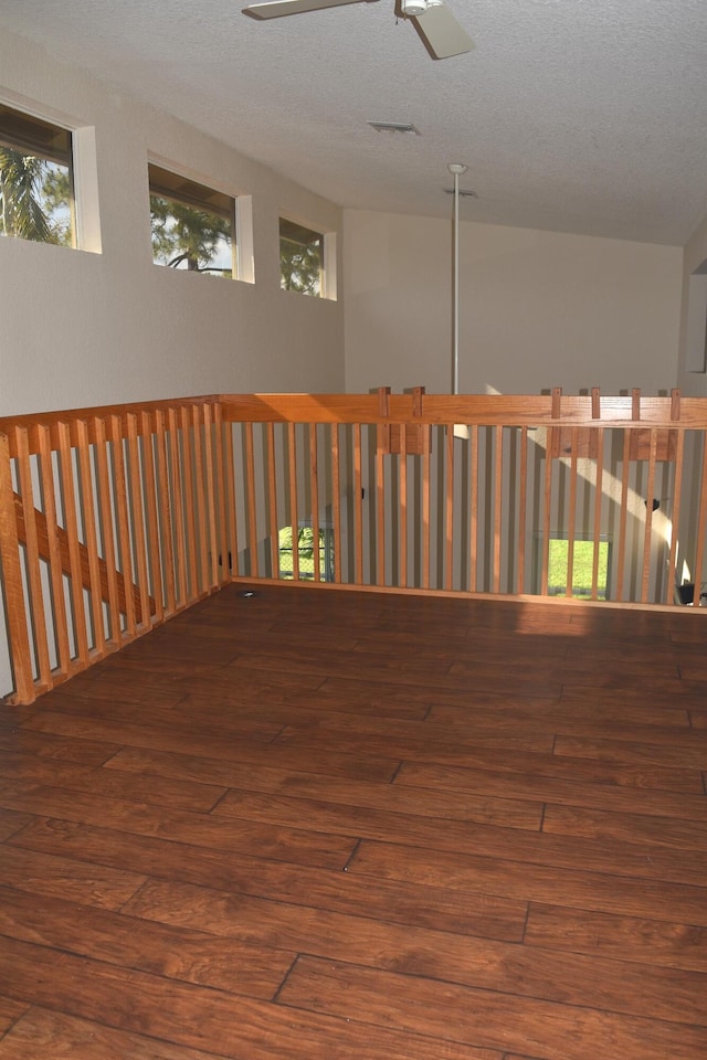 spare room featuring visible vents, hardwood / wood-style flooring, a wealth of natural light, and a textured ceiling