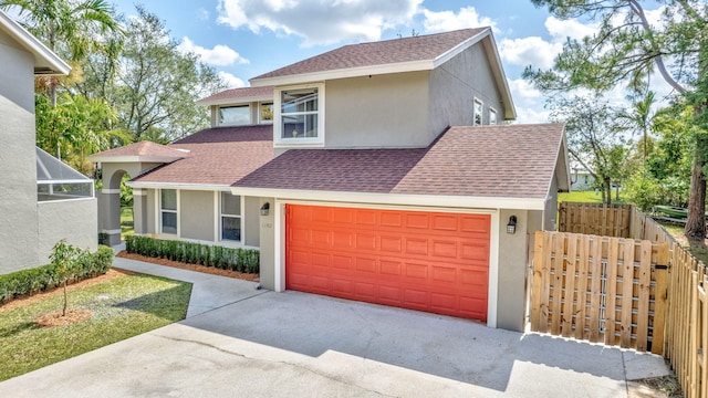 view of front of home featuring a shingled roof, fence, stucco siding, and driveway