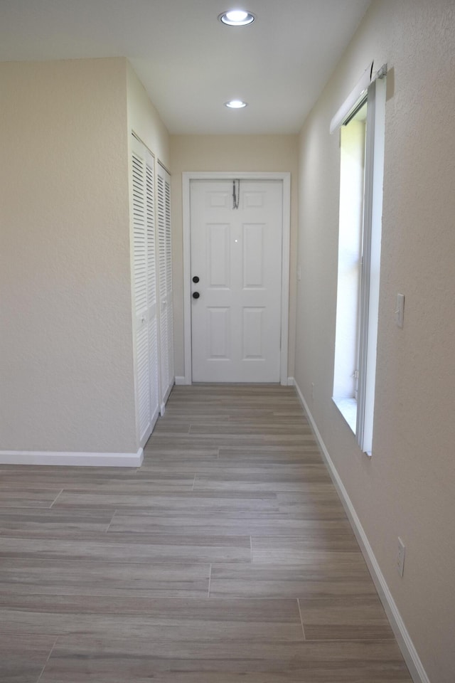 hall with baseboards, recessed lighting, and wood finished floors
