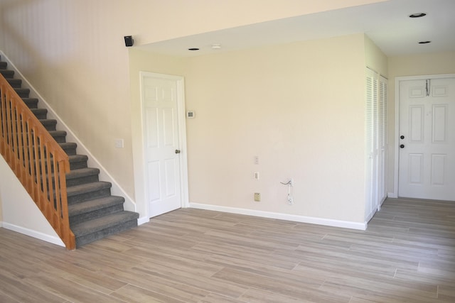 interior space with light wood finished floors, stairs, and baseboards