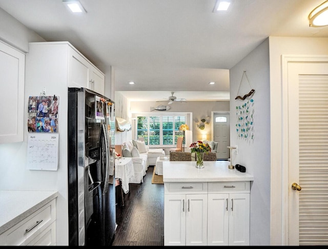kitchen featuring white cabinets, open floor plan, black fridge, recessed lighting, and dark wood-type flooring