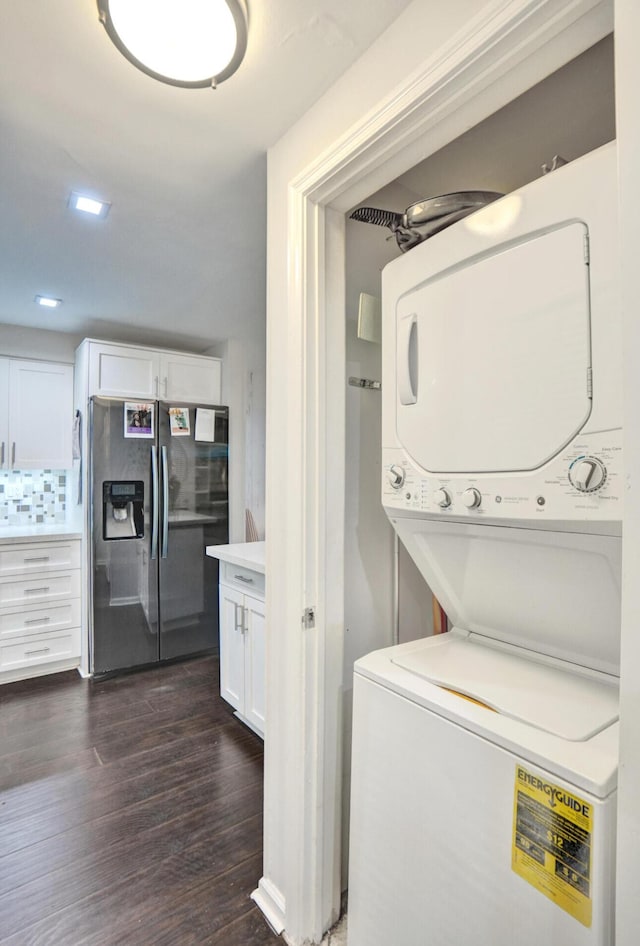 laundry room with recessed lighting, dark wood-style floors, and stacked washer / dryer